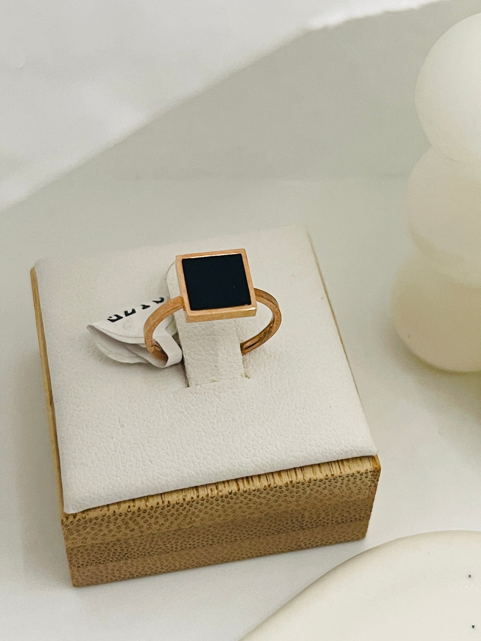 kids rose Gold ring with a black square stone on a white box