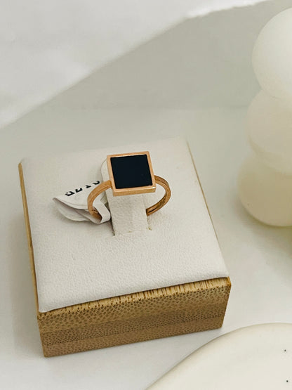 kids rose Gold ring with a black square stone on a white box