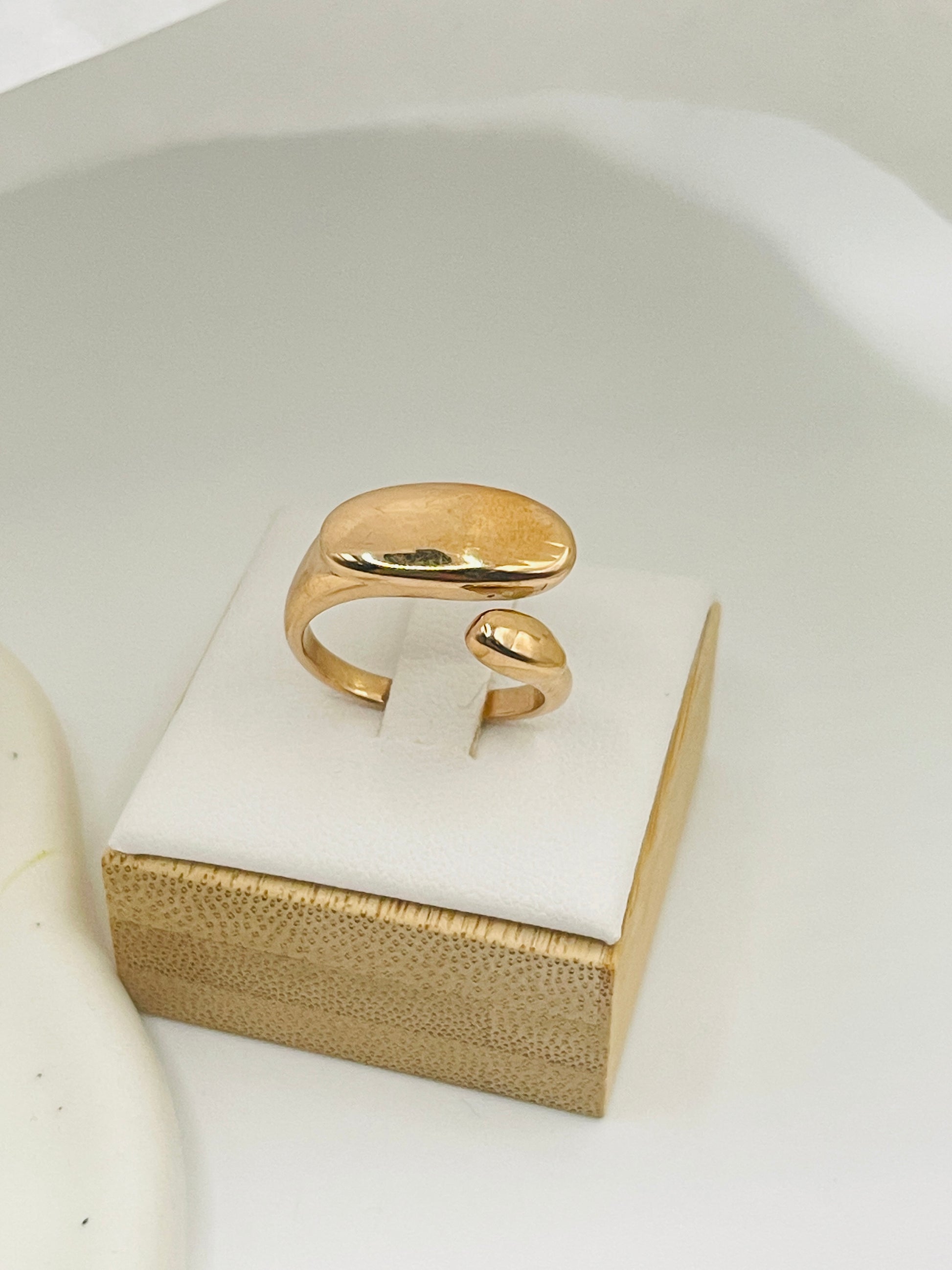 Rose Gold open ring on a white jewelry box with a gold base
