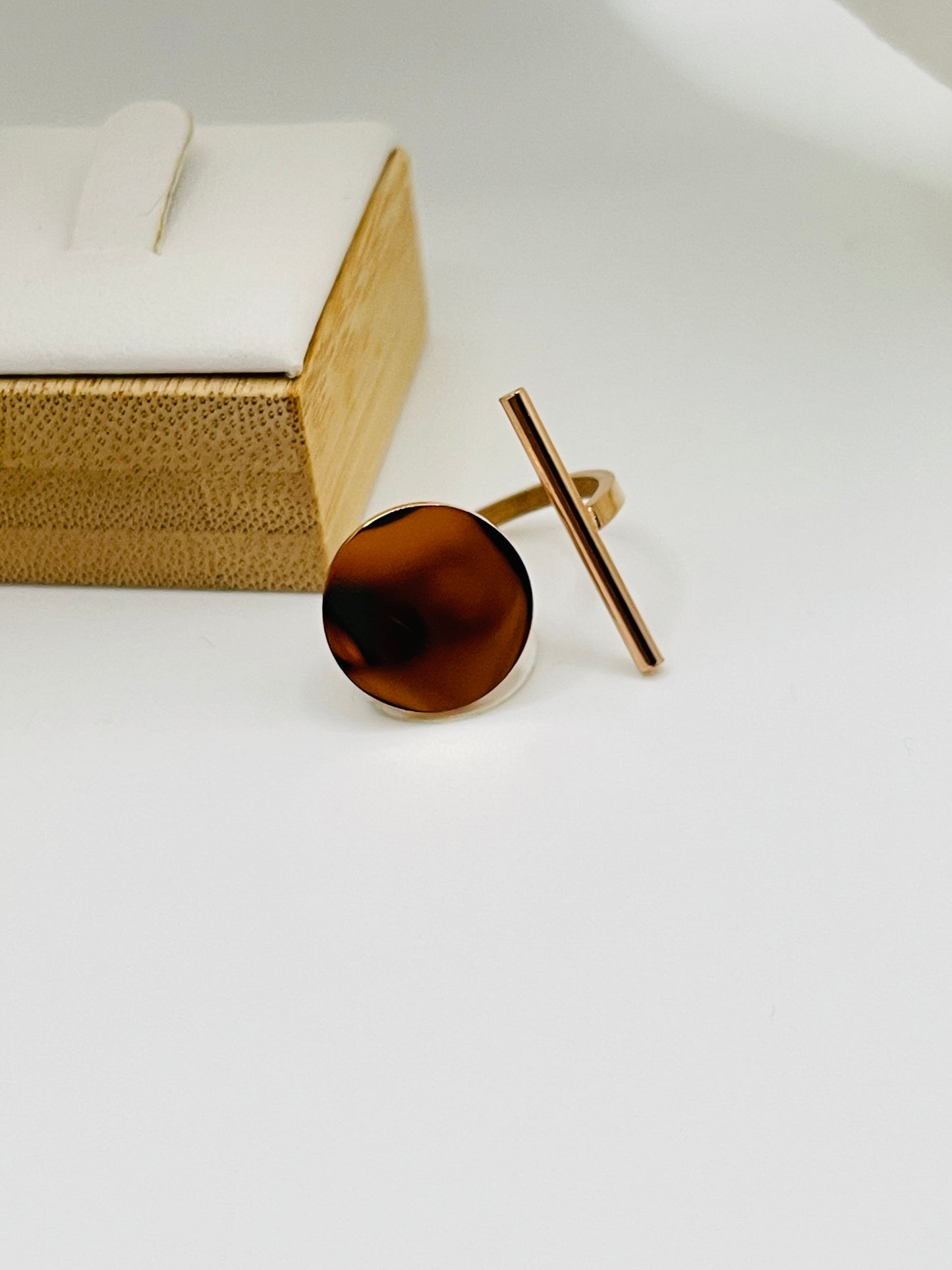 Rose Gold ring with a brown circular stone on a white surface