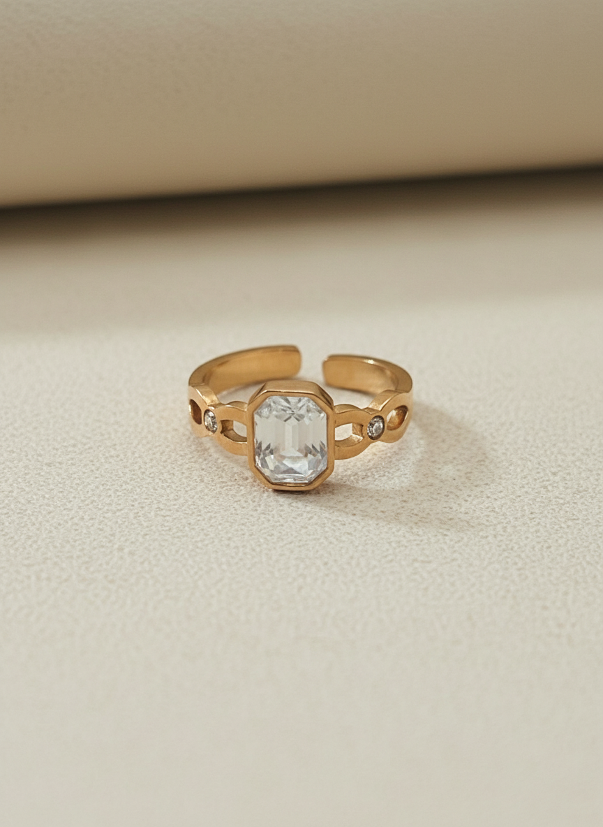 Rose Gold ring with a clear gemstone on a beige background
