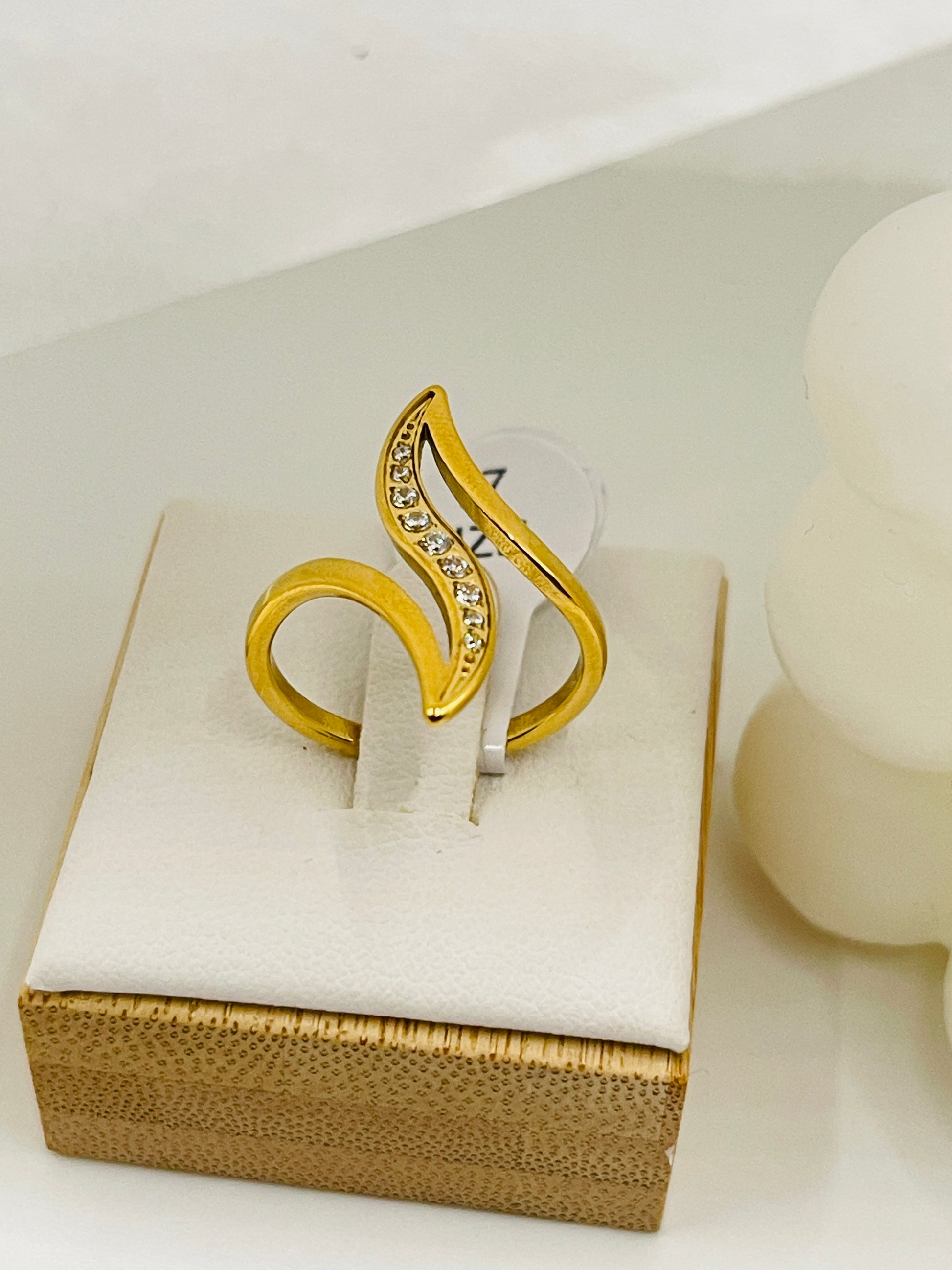 Gold ring with diamond accents on a white box