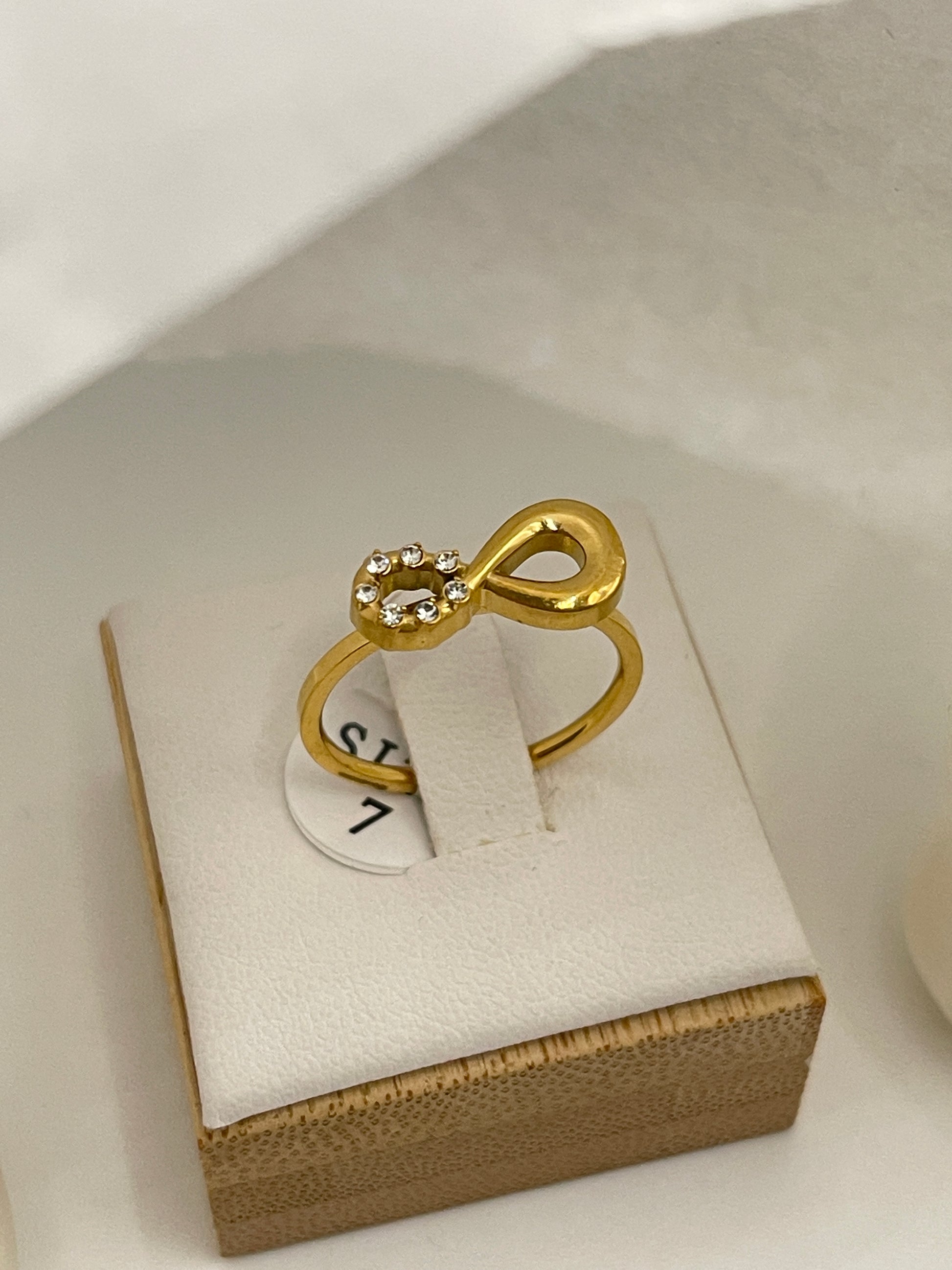 Gold ring with a unique design on a white box