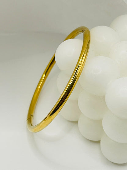 Gold bangle on a white background