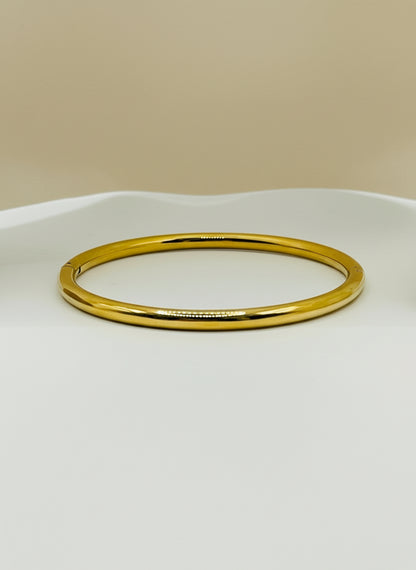 Gold bangle on a white background
