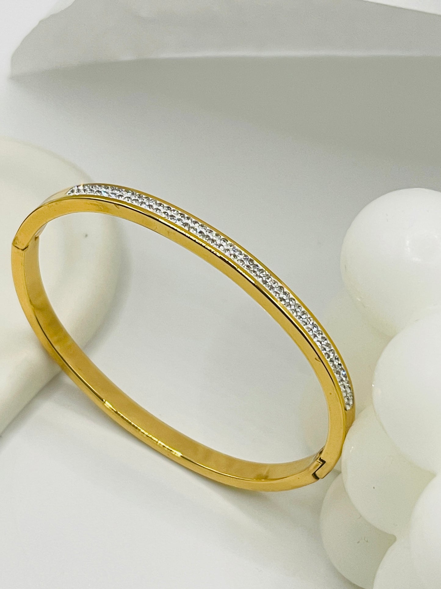 Gold bracelet with diamonds on a white background