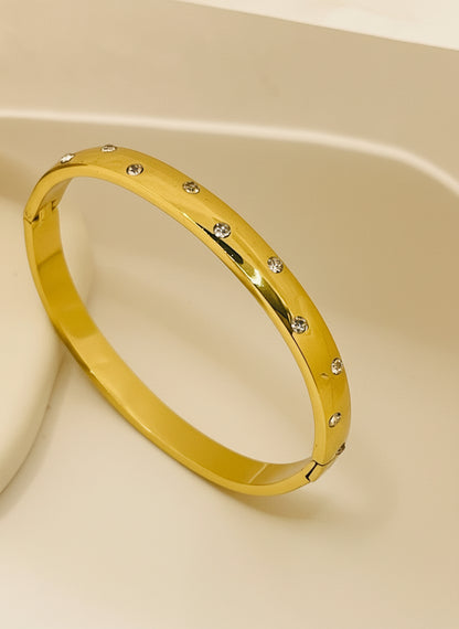 Gold bracelet with small stones on a white background