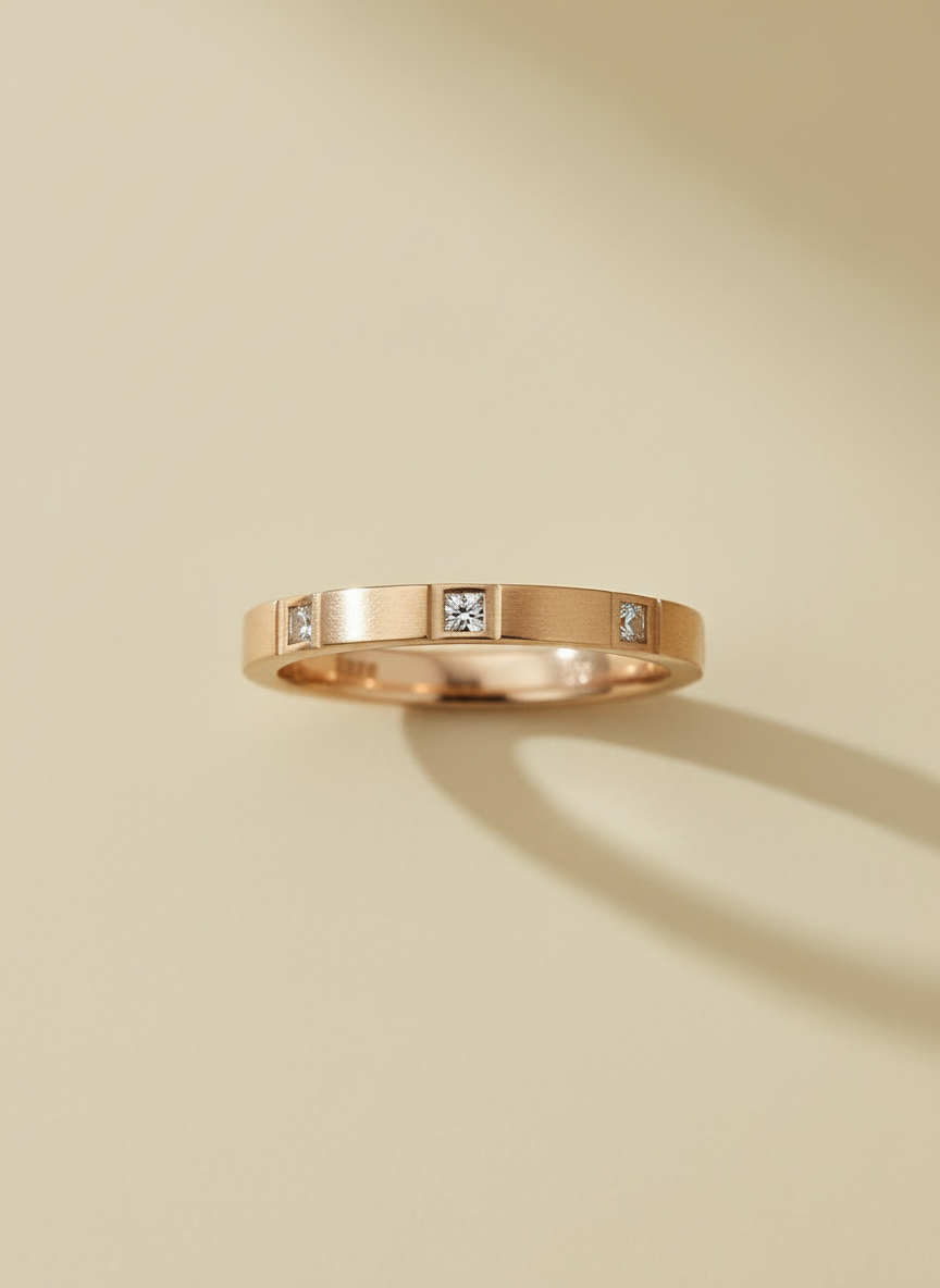 Rose gold ring with embedded diamonds on a beige background