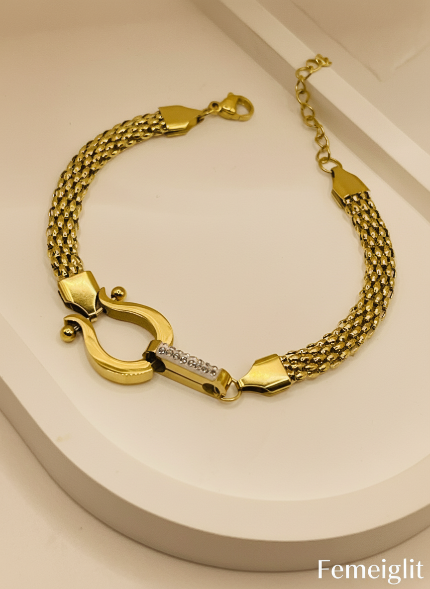 Gold bracelet with a clasp on a beige background