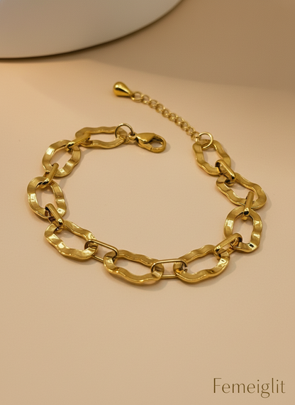 Gold chain bracelet on a beige background with 'Femeiglit' branding.