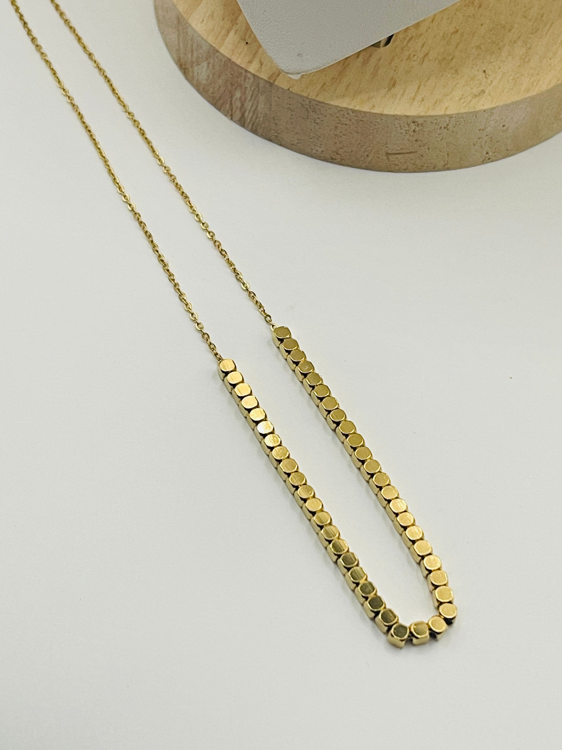 Gold necklace on a light gray background