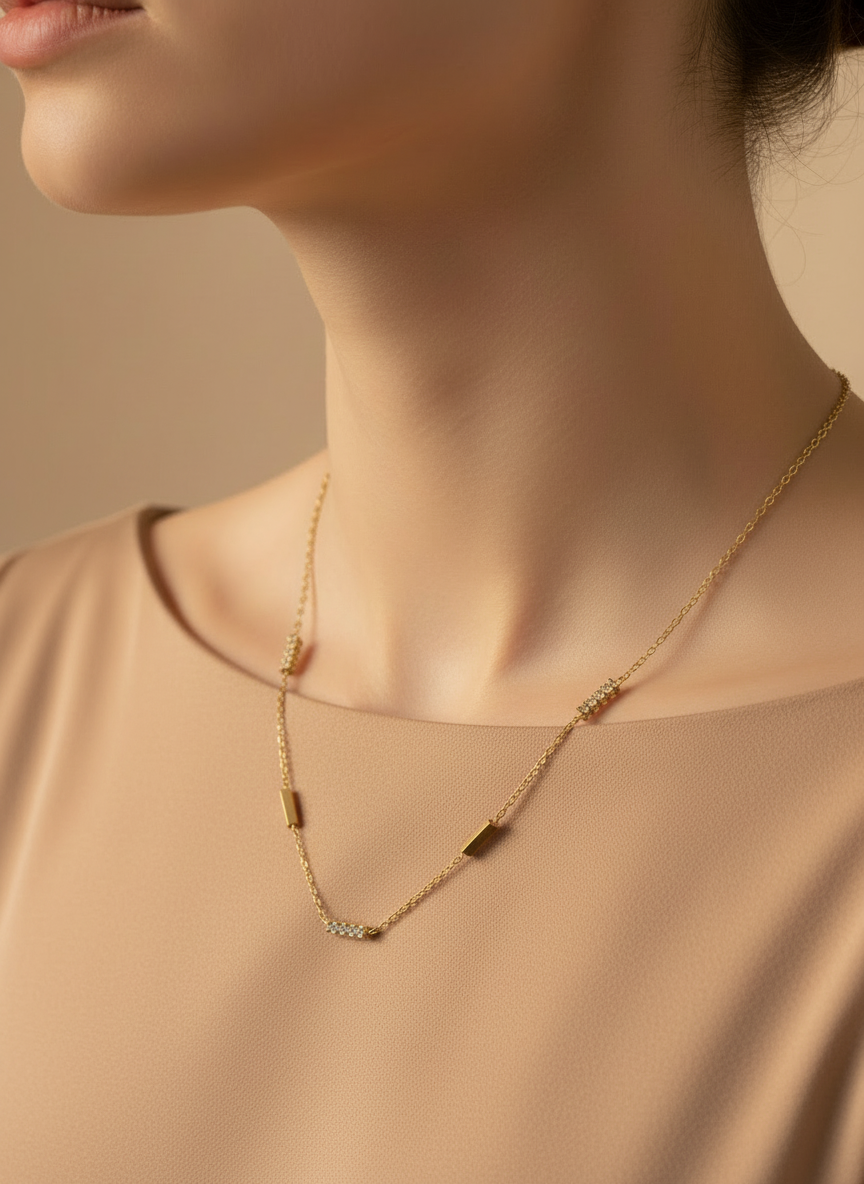 Gold necklace worn by a model with 'Femeiglit' branding.