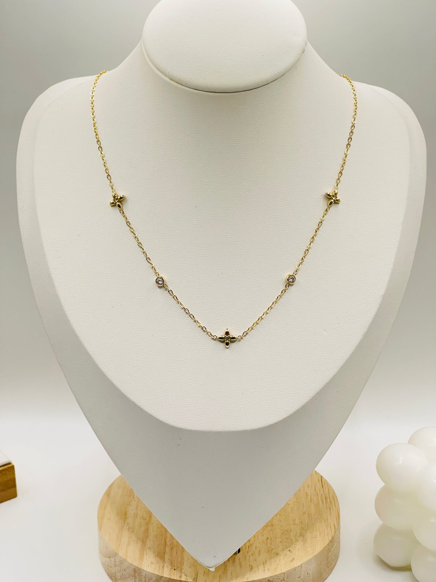 Gold necklace on a white mannequin bust with a light gray background