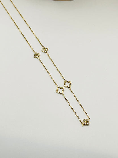 Gold necklace with heart-shaped charms on a light gray background