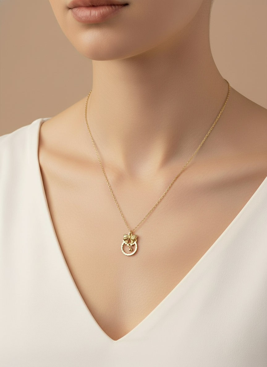 Gold necklace with a bow pendant on a white background