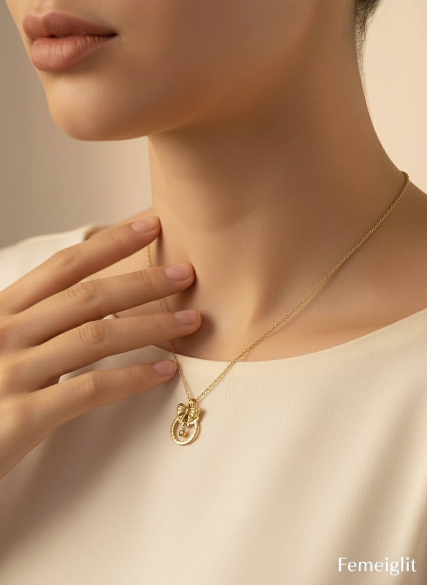 Gold necklace being worn on a mannequin with 'Femeiglit' branding.
