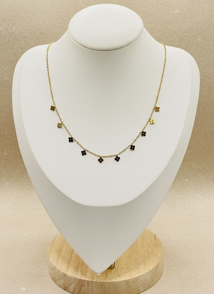 Gold necklace with black beads on a white mannequin bust