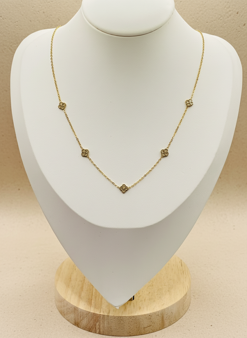 Gold necklace on a white mannequin bust with a beige background