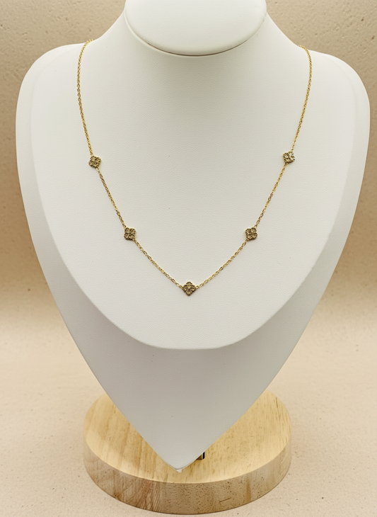 Gold necklace on a white mannequin bust with a beige background