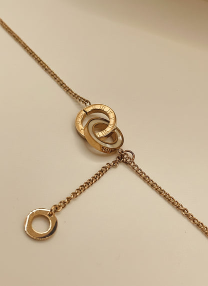 Rose gold chain bracelet 
with interlocking rings on a light gray background