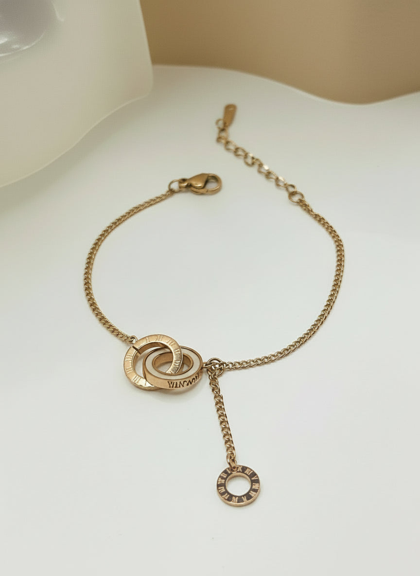 Rose gold bracelet with chain and circular design on a light background