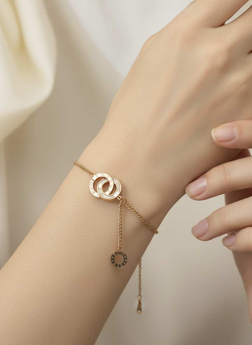 Rose gold bracelet with circular design on a wrist against a neutral background