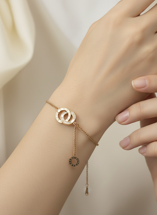 Rose gold bracelet with circular design on a wrist against a neutral background