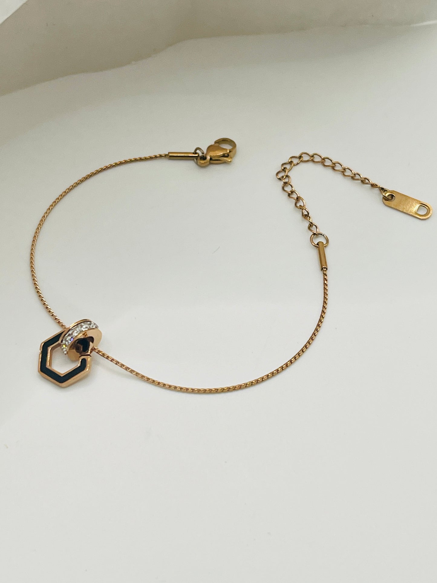 Rose Gold bracelet with hexagonal charm on a white background