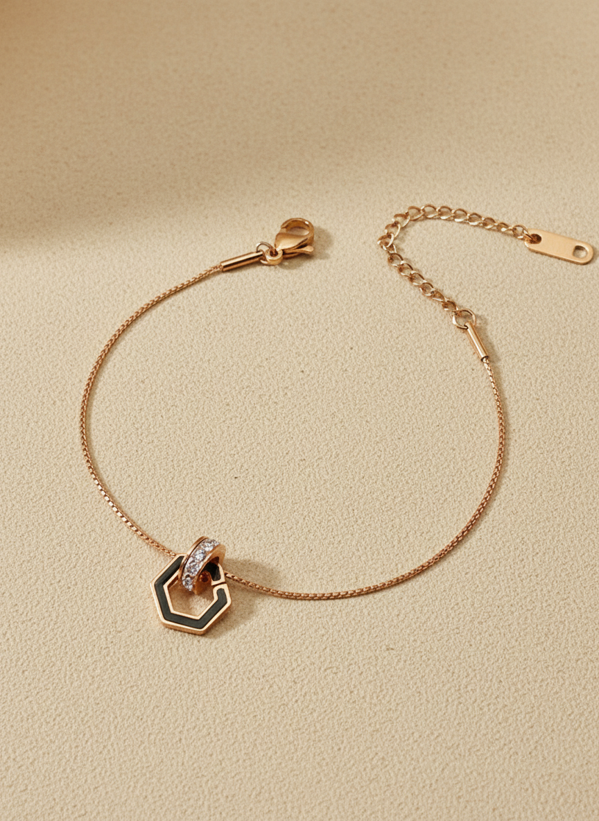 Rose gold bracelet with a hexagonal clasp on a beige background