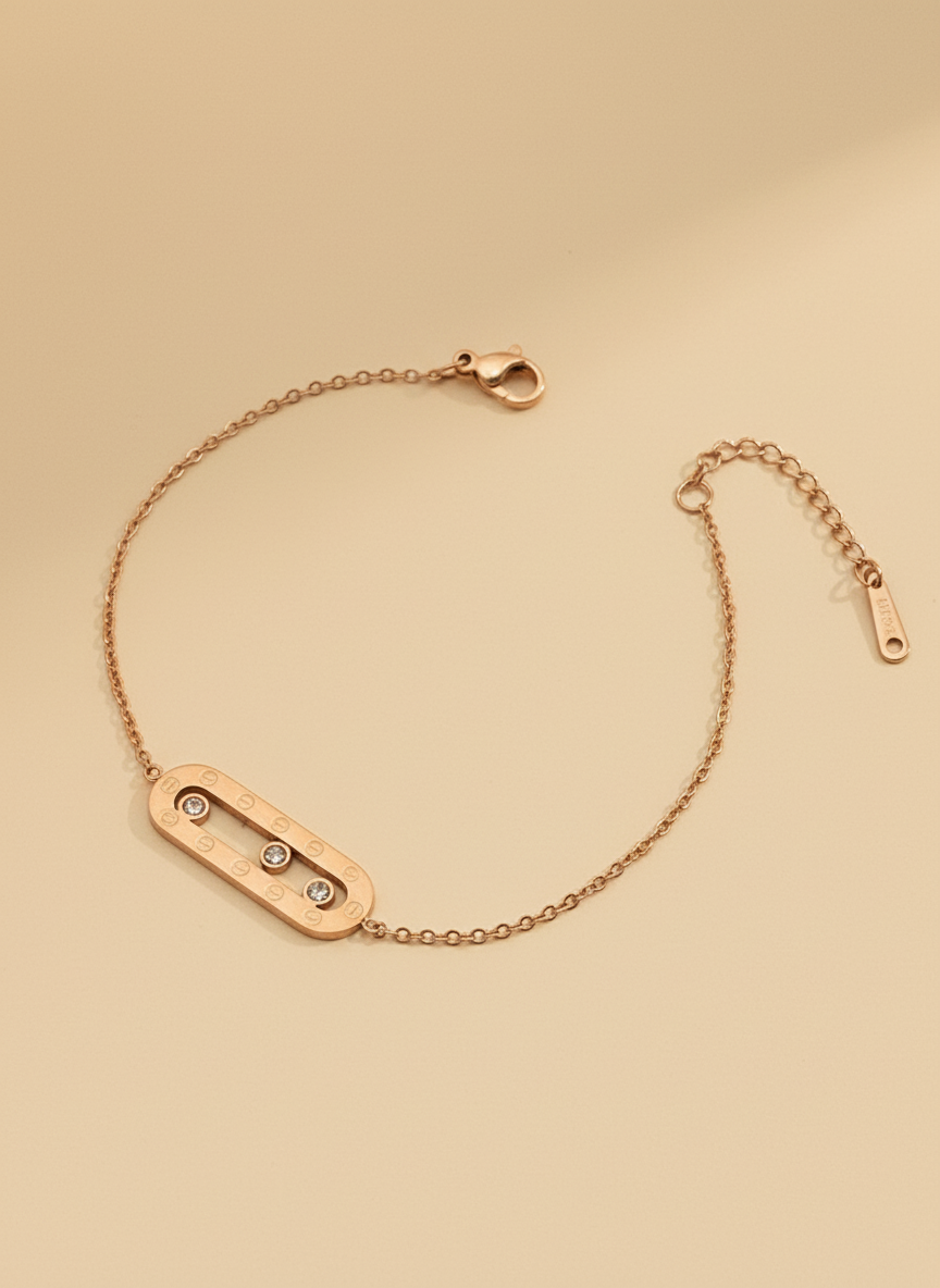 Rose gold bracelet with three small diamonds on a beige background