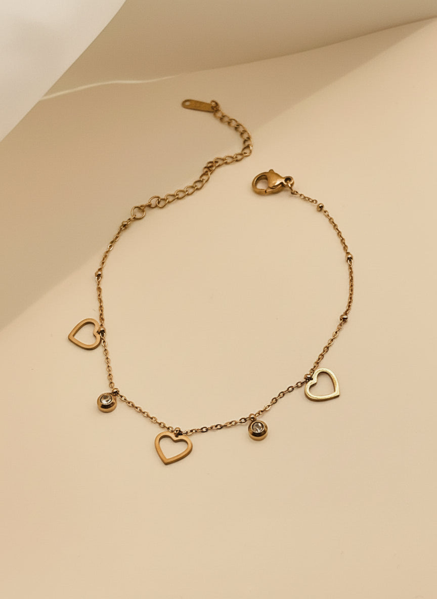 Rose Gold bracelet with heart-shaped charms on a light background