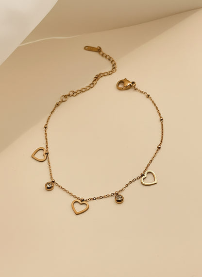 Rose Gold bracelet with heart-shaped charms on a light background