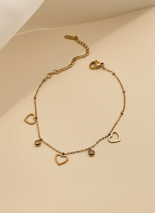 Rose Gold bracelet with heart-shaped charms on a light background