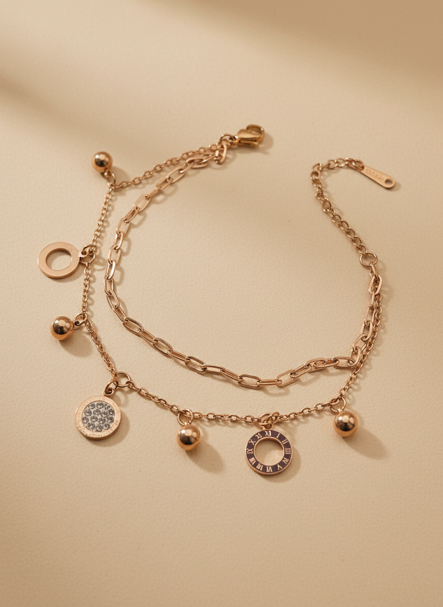Rose gold bracelet with charms on a beige background