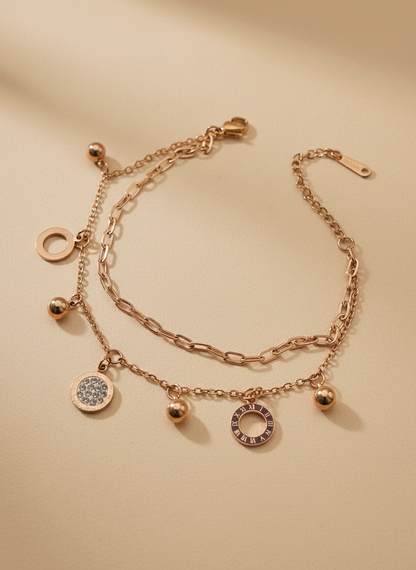 Rose gold bracelet with charms on a beige background