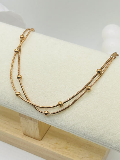 Rose Gold bracelet on a white cushion with a light wooden base