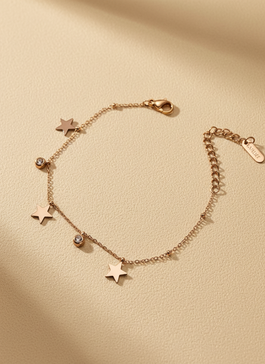 Rose gold bracelet with star charms on a beige background