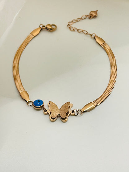 Rose Gold bracelet with a butterfly charm and blue gemstone on a white background