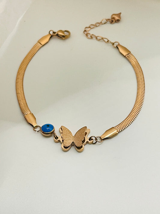 Rose Gold bracelet with a butterfly charm and blue gemstone on a white background