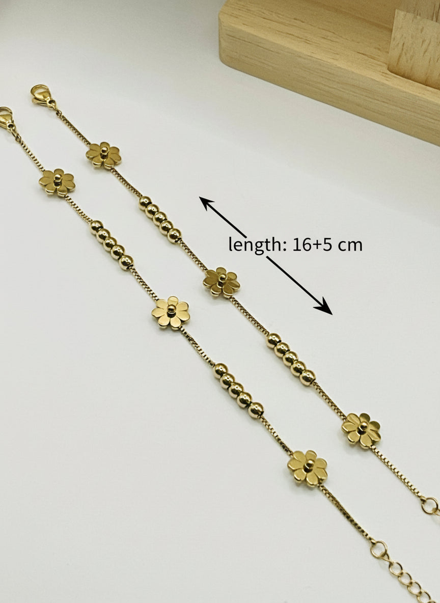 Gold kids anklet with floral designs on a white surface