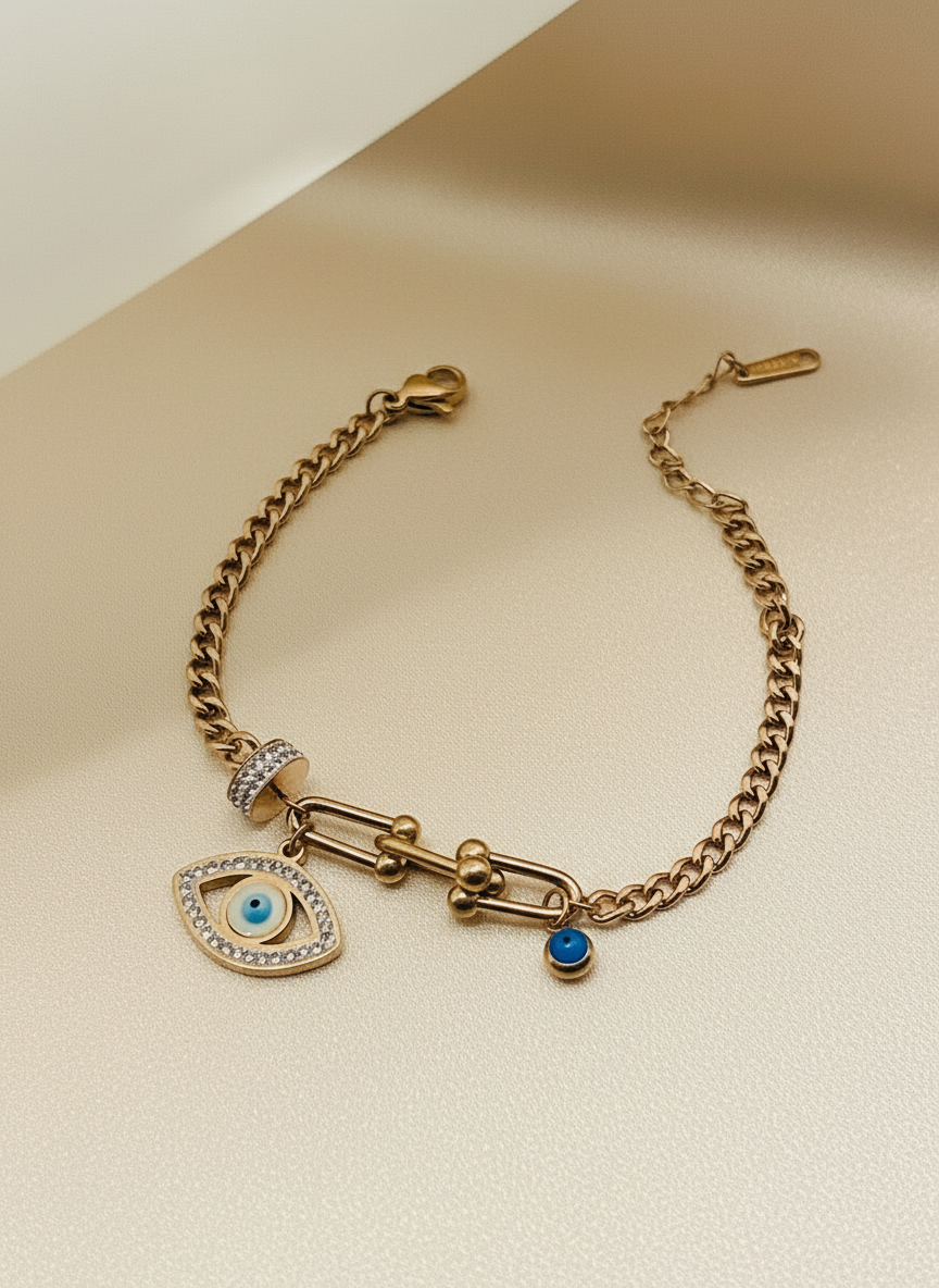 Rose Gold bracelet with eye charm and blue gemstone on a beige background