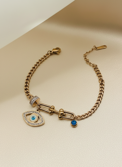 Rose Gold bracelet with eye charm and blue gemstone on a beige background