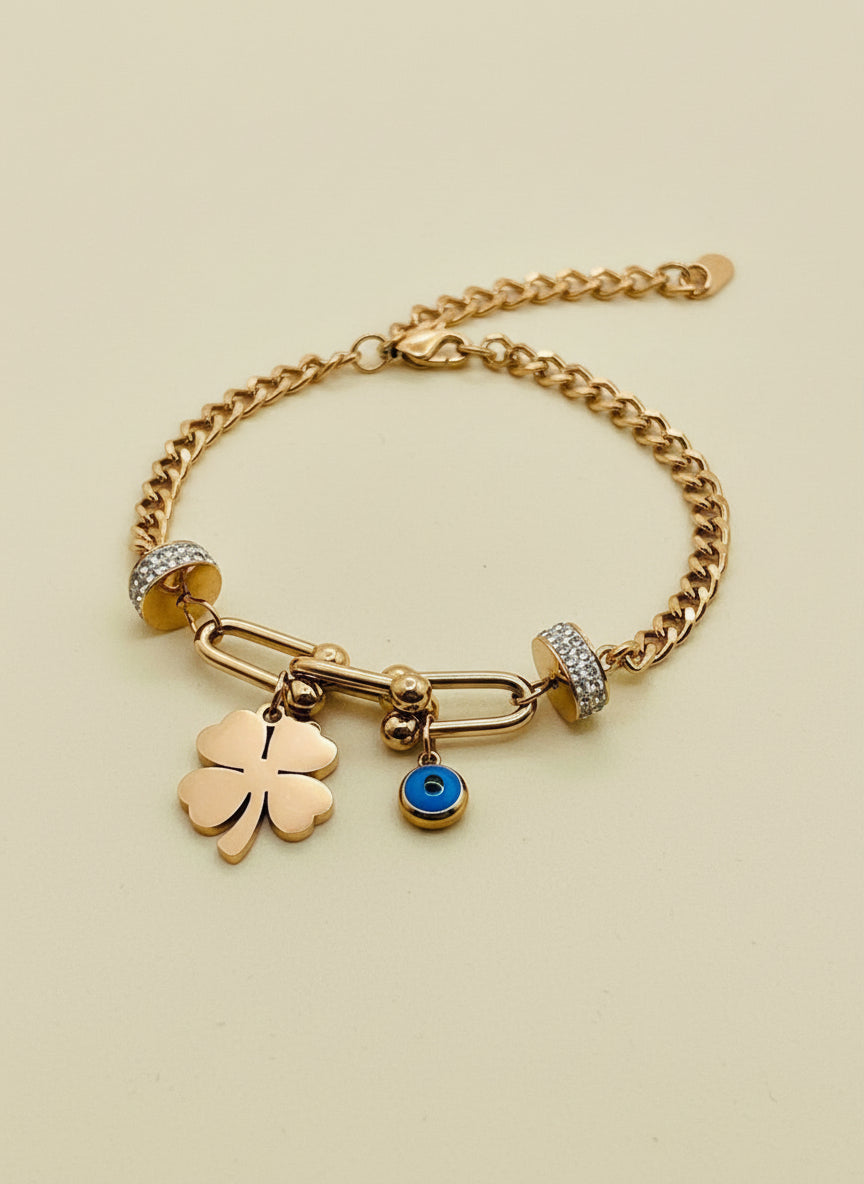 Rose Gold chain bracelet with charms on a white stand