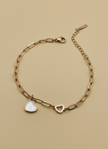 Rose Gold chain bracelet with heart-shaped charms on a beige background