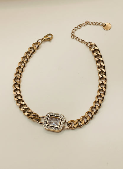 Rose Gold chain bracelet with a square gemstone on a light gray background