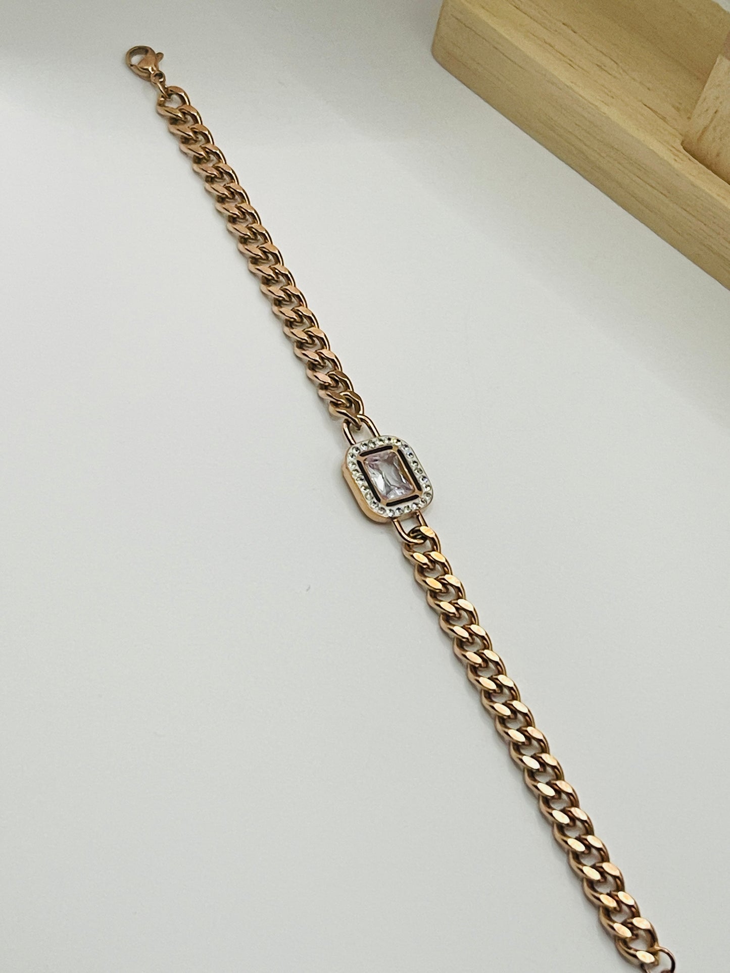 Rose Gold chain bracelet with a diamond clasp on a white background