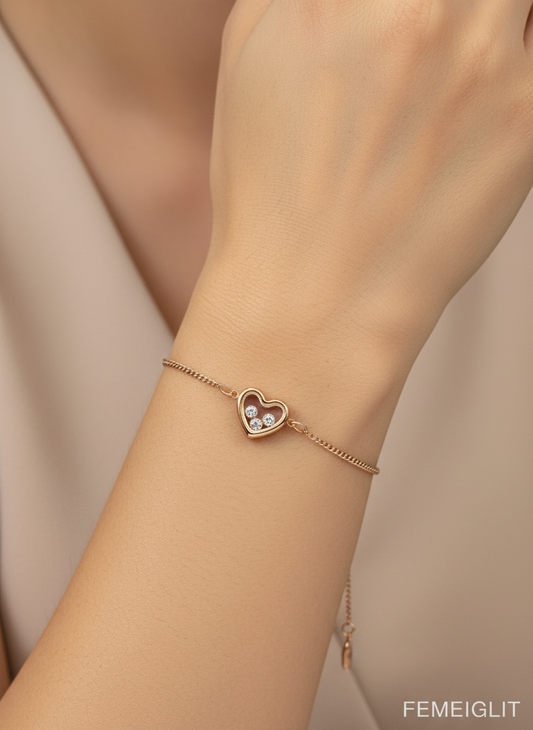 Rose gold bracelet with a heart-shaped clasp on a wrist against a neutral background