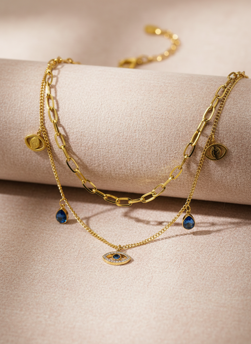 Gold chain bracelet with blue gemstones on a beige surface
