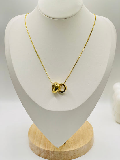 Gold necklace on a white mannequin bust with a wooden base