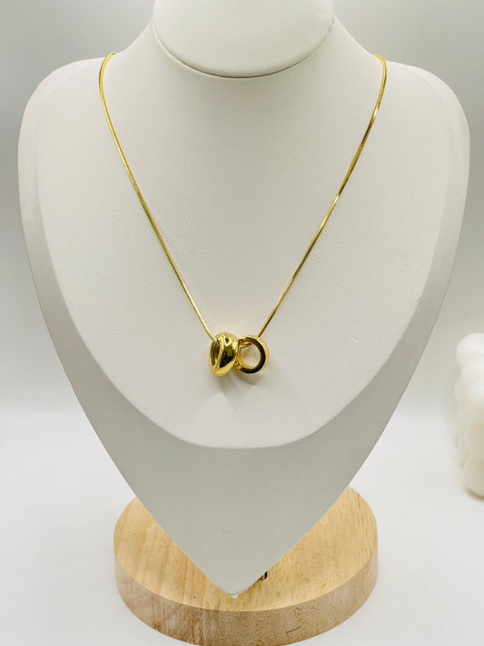 Gold necklace on a white mannequin bust with a wooden base